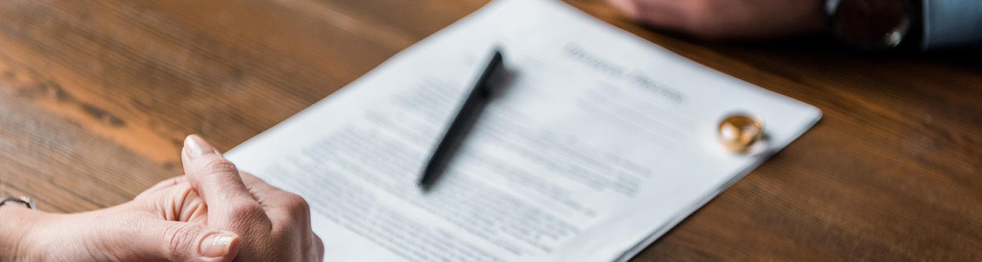 Signature d’un document illustrant la gestion des dettes divorce entre époux